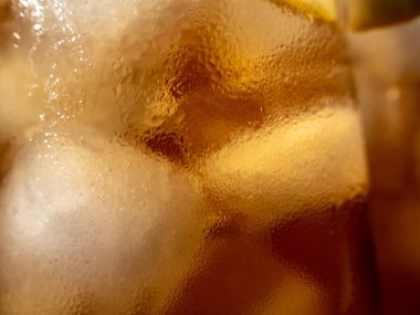 Buzlu bir bardaktaki buzlu çayın arka planı. Buzlu çay. Yakın plan..