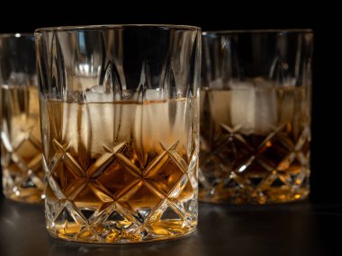 Viski, burbon ya da siyah arka planda buzlu konyak. Yakın plan..