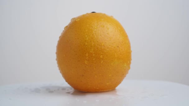 熟したオレンジを回転させます 軽い背景に新鮮なジューシーなオレンジ 接近中だ 高品質4K映像 — ストック動画