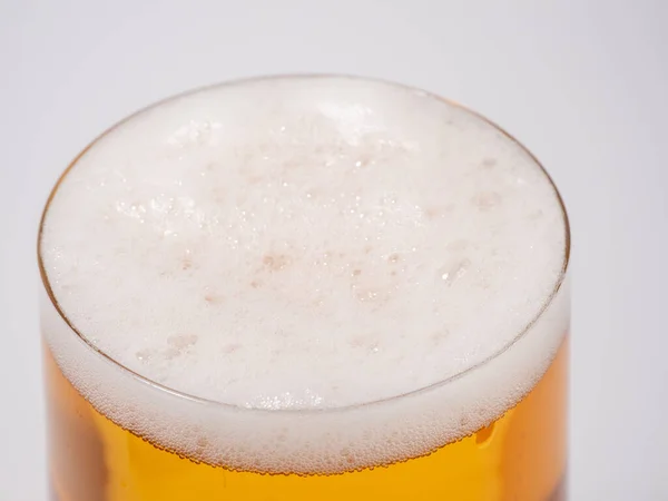 Glass of beer on a white background. A glass of light beer with foam. close-up.