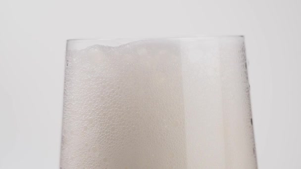 Ποτήρι Μπύρας Φυσαλίδες Λευκό Φόντο Ένα Ποτήρι Ελαφριά Μπύρα Αφρό — Αρχείο Βίντεο