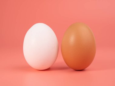 Pembe arka planda tavuk yumurtası. Pembe arka planda beyaz ve kahverengi yumurta. Yakın plan..