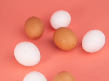 Pembe arka planda tavuk yumurtası. Pembe arka planda beyaz ve kahverengi yumurta. Yakın plan..