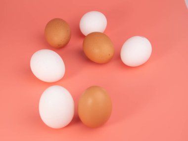 Pembe arka planda tavuk yumurtası. Pembe arka planda beyaz ve kahverengi yumurta. Yakın plan..