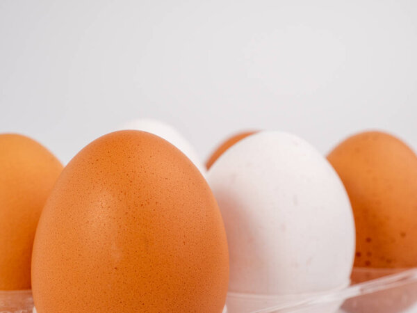 Chicken eggs on a white background. White and brown egg on a white background. Close-up.