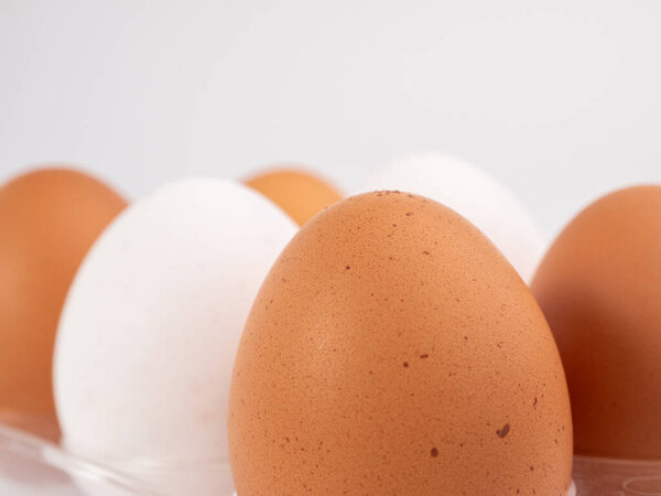 Chicken eggs on a white background. White and brown egg on a white background. Close-up.