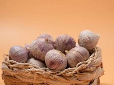 Turuncu arka planda sarımsak kafalar. Yakın plan..