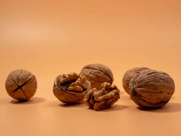 stock image Walnut on an orange background. Raw walnut. Close-up.