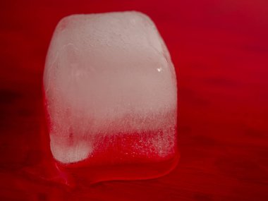 Kırmızı zemin üzerinde buz küpleri. Kırmızıda buz. Yakın plan..