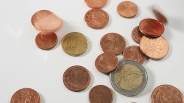 Metal madeni paraların beyaz bir masaya düşmesi. Eurocent 'ler masaya dökülüyor. Yüksek kalite 4k görüntü