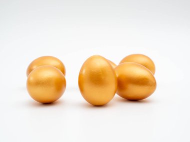 Beyaz arka planda altın yumurtalar. Altın tavuk yumurtası. Zenginlik sembolü.