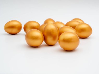 Beyaz arka planda altın yumurtalar. Altın tavuk yumurtası. Zenginlik sembolü.