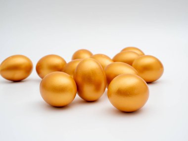 Beyaz arka planda altın yumurtalar. Altın tavuk yumurtası. Zenginlik sembolü.