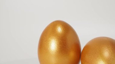 Beyaz arka planda altın yumurtalar. Altın tavuk yumurtası. Zenginlik sembolü. Yüksek kalite 4k görüntü