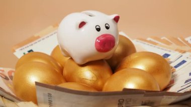 Altın yumurta, para ve kumbara. Altın tavuk yumurtası ve euro banknotları. Zenginlik sembolü. Yüksek kalite 4k görüntü