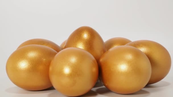 白い背景に金色の卵 黄金の鶏の卵 富の象徴だ 高品質4K映像 — ストック動画