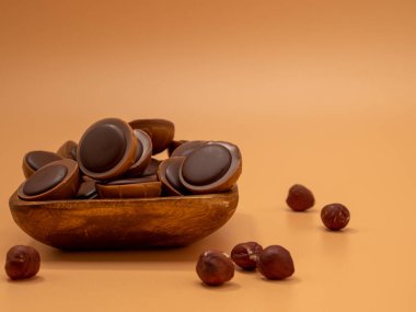 Turuncu arka planda çikolatalı şekerler. Karamelli tatlılar. Yuvarlak çikolatalar. Yakın plan..