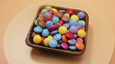 Küçük renkli yuvarlak şekerler. Şekerleme ile kaplı dönen şekerler. 