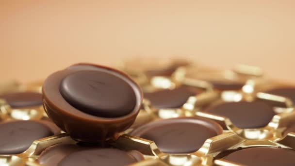 巧克力糖果在橙色背景下旋转 糖与焦糖 巧克力 后续行动 — 图库视频影像