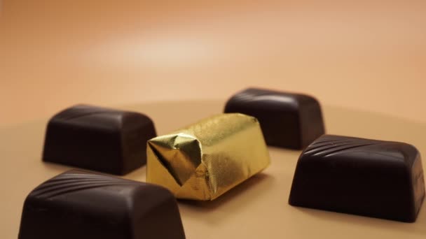 巧克力糖果在橙色背景下旋转 加料糖果 — 图库视频影像