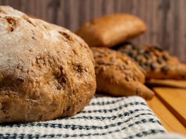 Ahşap arka planda siyah ekmek ve çörekler. Tahıllı fırın ürünleri. Yakın plan..