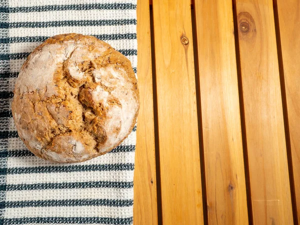 Dark bread on a wooden background. Round Bread with grains. Close-up.