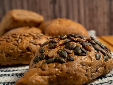 Ahşap arka planda siyah çörekler. Tahıllı fırın ürünleri. Yakın plan..