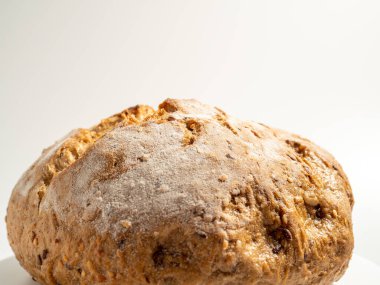 Beyaz arka planda siyah ekmek. Tahıllı yuvarlak ekmek. Yakın plan..