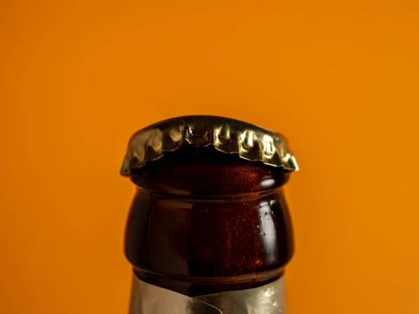 The neck of an open bottle of beer. Close-up.