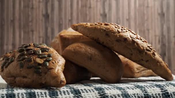 木製の背景に暗いパンを回転させます 穀物入りベーカリー製品 — ストック動画