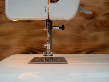 Electric sewing machine on a wooden background. Close-up.