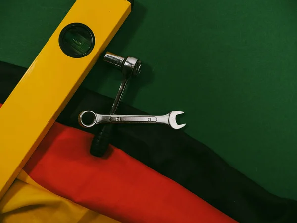 German flag and work tool on green. Concept Made in Germany. German quality.