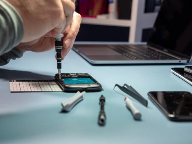A technician repairs a smartphone in a laboratory with copy space. concept of computer hardware, mobile phones, electronics, repair, upgrade and technology. Close-up.
