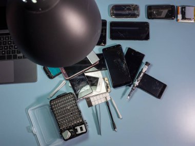Old broken smartphone and repair tool. The concept of computer equipment, mobile phones, electronics, repair, modernization and technology. Close-up.