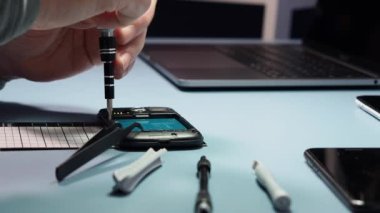 A technician repairs a smartphone in a laboratory with copy space. concept of computer hardware, mobile phones, electronics, repair, upgrade and technology. Close-up.