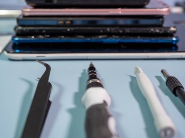 Old broken smartphone and repair tool. The concept of computer equipment, mobile phones, electronics, repair, modernization and technology. Close-up.