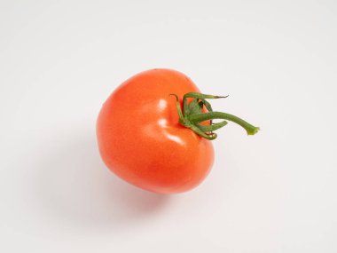 Red tomato on a white background. Fresh tomato. Close-up.