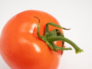 Red tomato on a white background. Fresh tomato. Close-up.