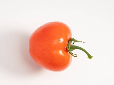 Red tomato on a white background. Fresh tomato. Close-up.