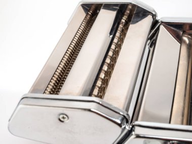 Hand machine for rolling out dough and pasta. Noodle cutter. Chrome plated steel. Anodized aluminum. White background.