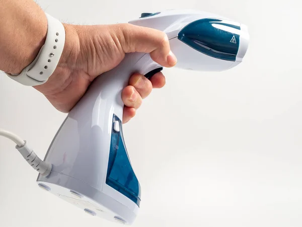In hand Steamer for clothes on a white background. Portable iron. Iron for ironing clothes.