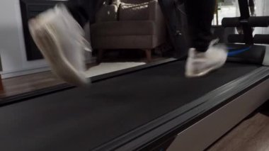 Bir adam evinde koşu bandında koşuyor. Koşu bandında kardiyo çalışması. Spor..