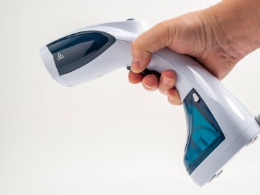 Beyaz arka plandaki giysiler için buharlı gemi. Taşınabilir demir. Ütü için ütü..