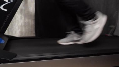 Bir adam evinde koşu bandında koşuyor. Koşu bandında kardiyo çalışması. Spor..
