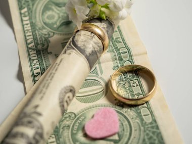 Wedding rings and dollars. The concept of marriage of convenience. Close-up.
