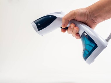 Beyaz arka plandaki giysiler için buharlı gemi. Taşınabilir demir. Ütü için ütü..