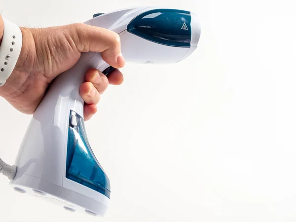 In hand Steamer for clothes on a white background. Portable iron. Iron for ironing clothes.