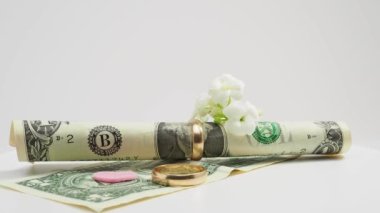Evlilik yüzükleri ve dolar. Mantık evliliği kavramı. Yakın plan..