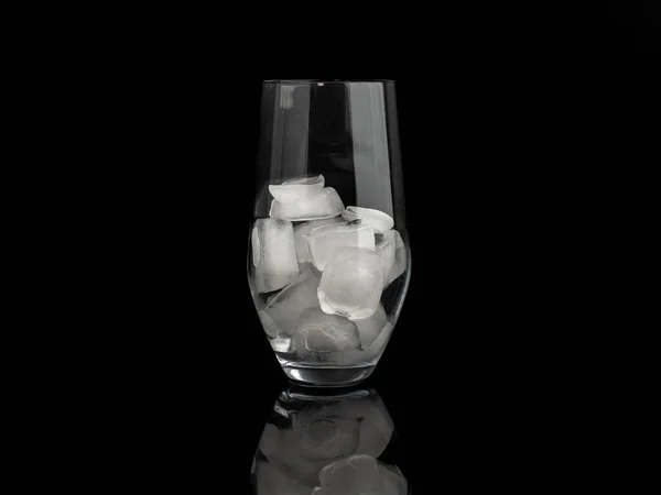 Glass with ice on a black background. Close-up.