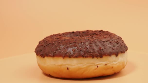 Rotating Chocolate Donut Chocolate Chips Orange Background Close — Vídeo de Stock